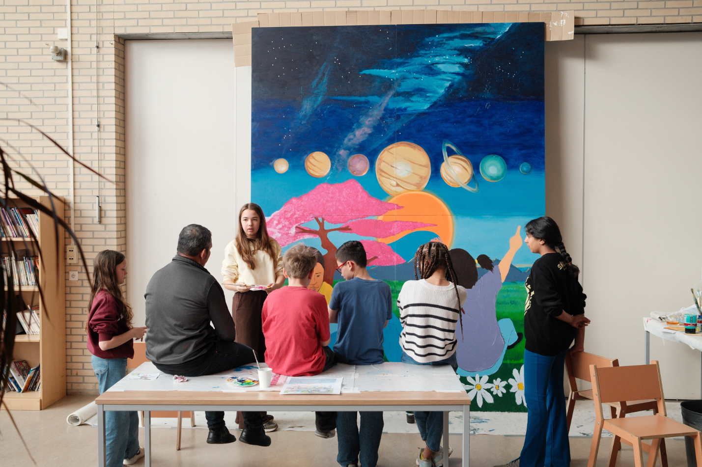Kinderen en kunstenaar bij muurschildering