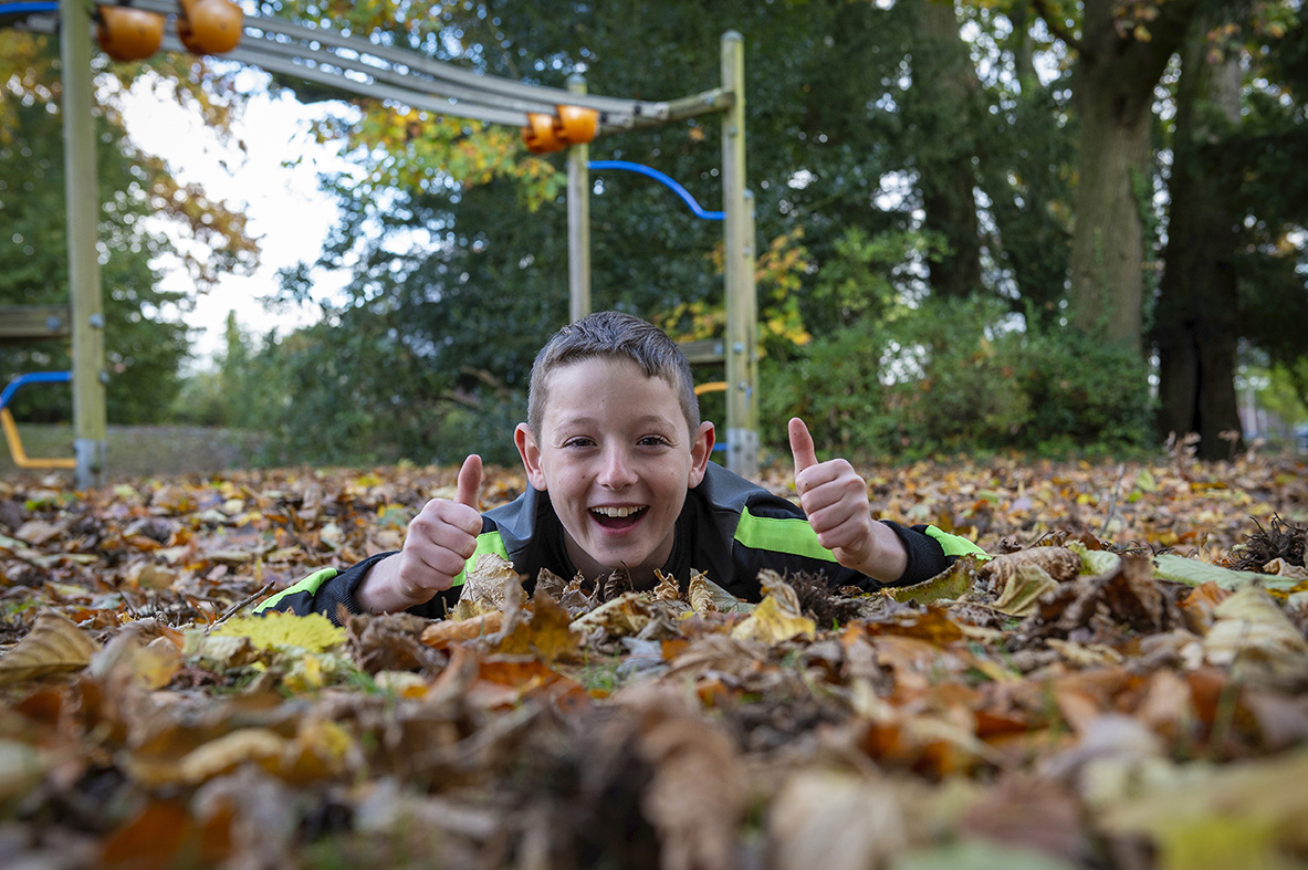 Jongen in bladeren