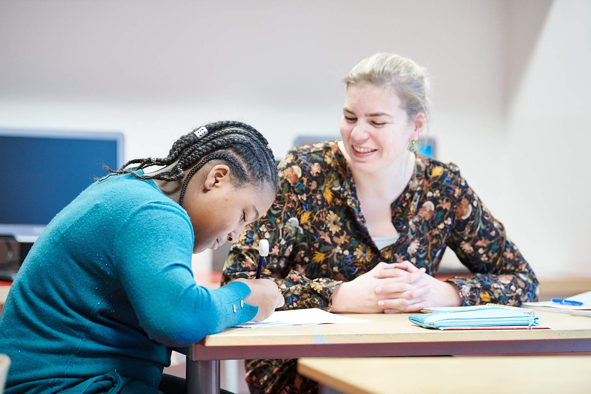 Leerkracht legt iets uit aan leerling