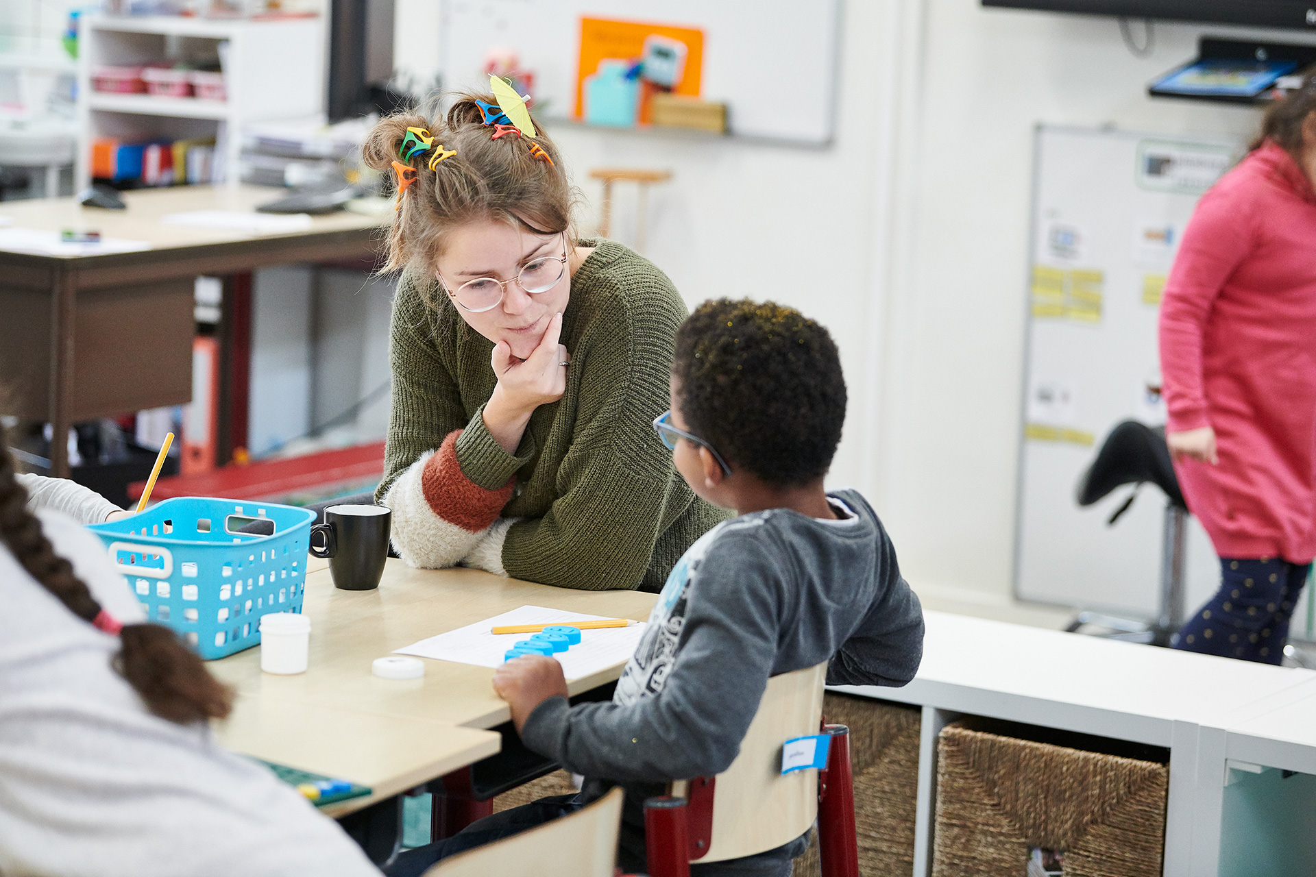 Leerkracht legt iets uit aan leerling