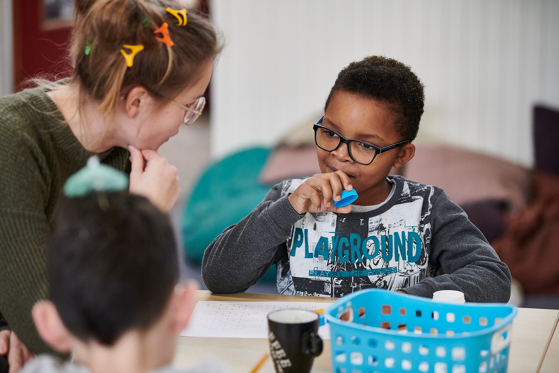 Leerkracht legt iets uit aan leerling