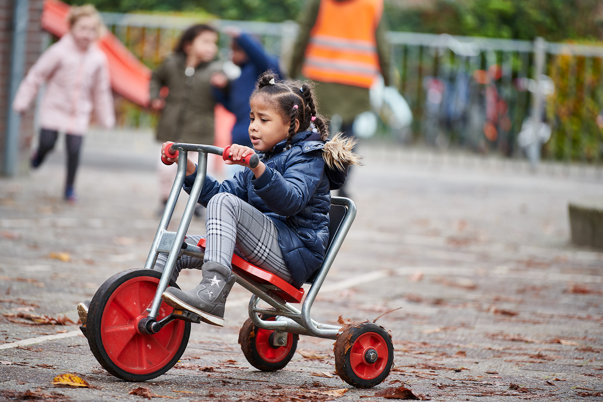Leerling op een fietsje op het schoolplein