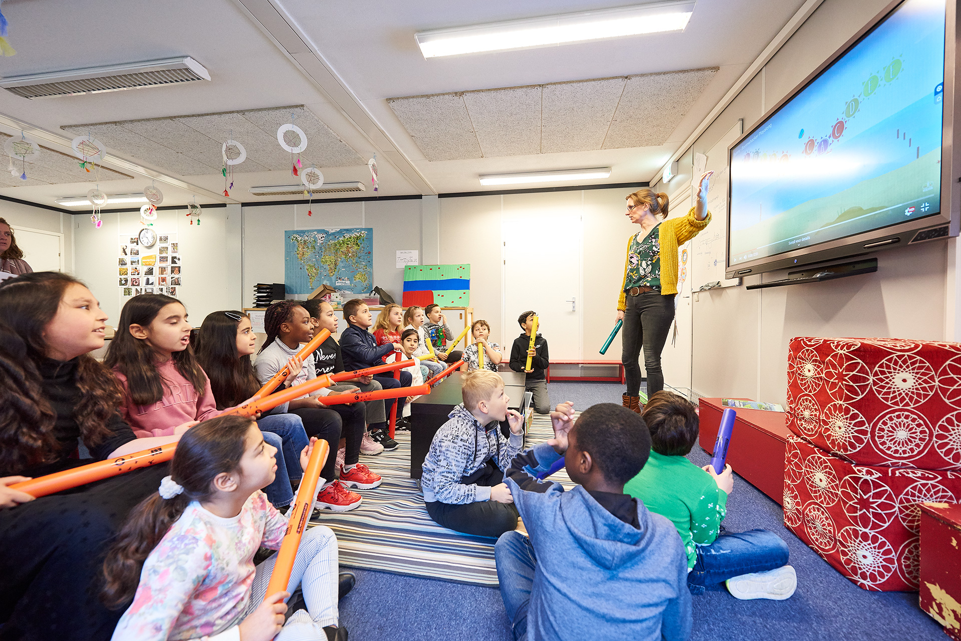 Leerkracht staat iets uit te leggen voor de klas