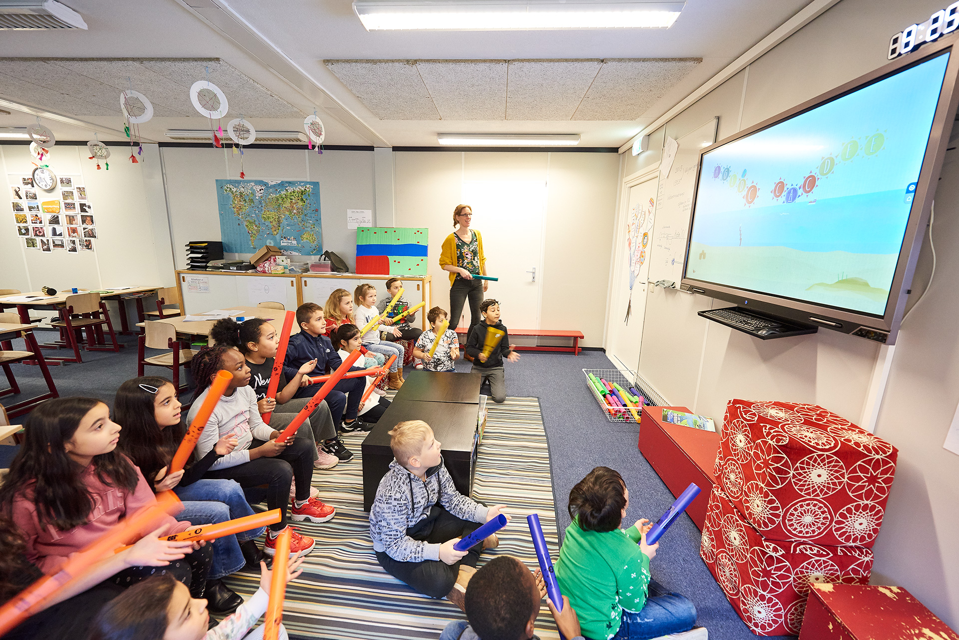 Leerkracht staat iets uit te leggen voor de klas