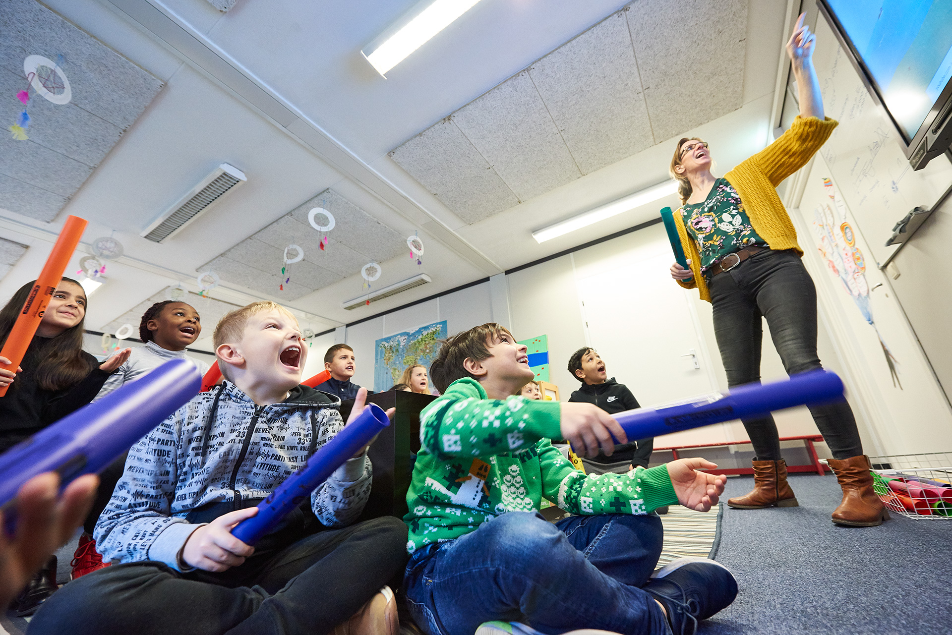 Leerkracht staat iets uit te leggen voor de klas