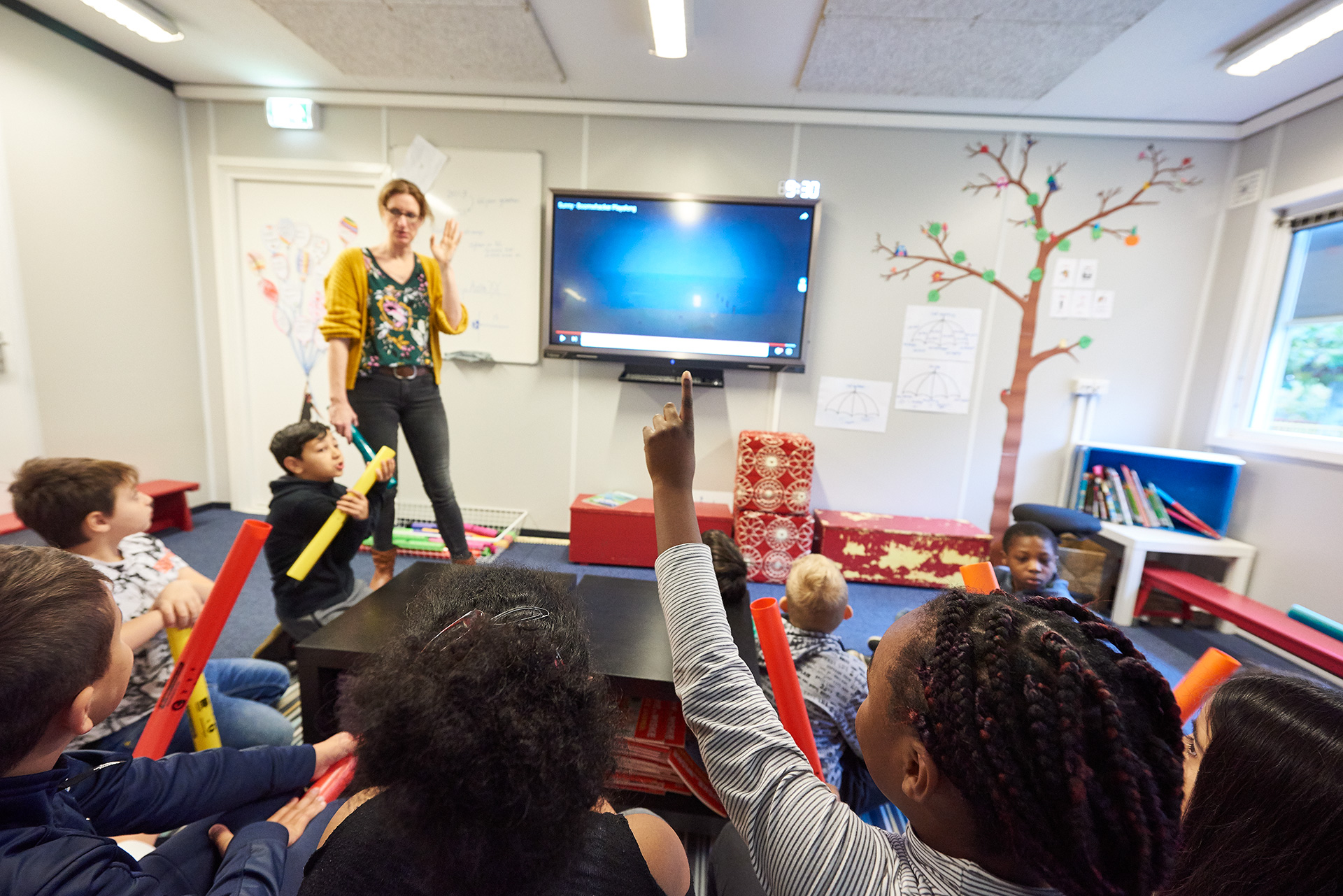 Leerkracht staat iets uit te leggen voor de klas