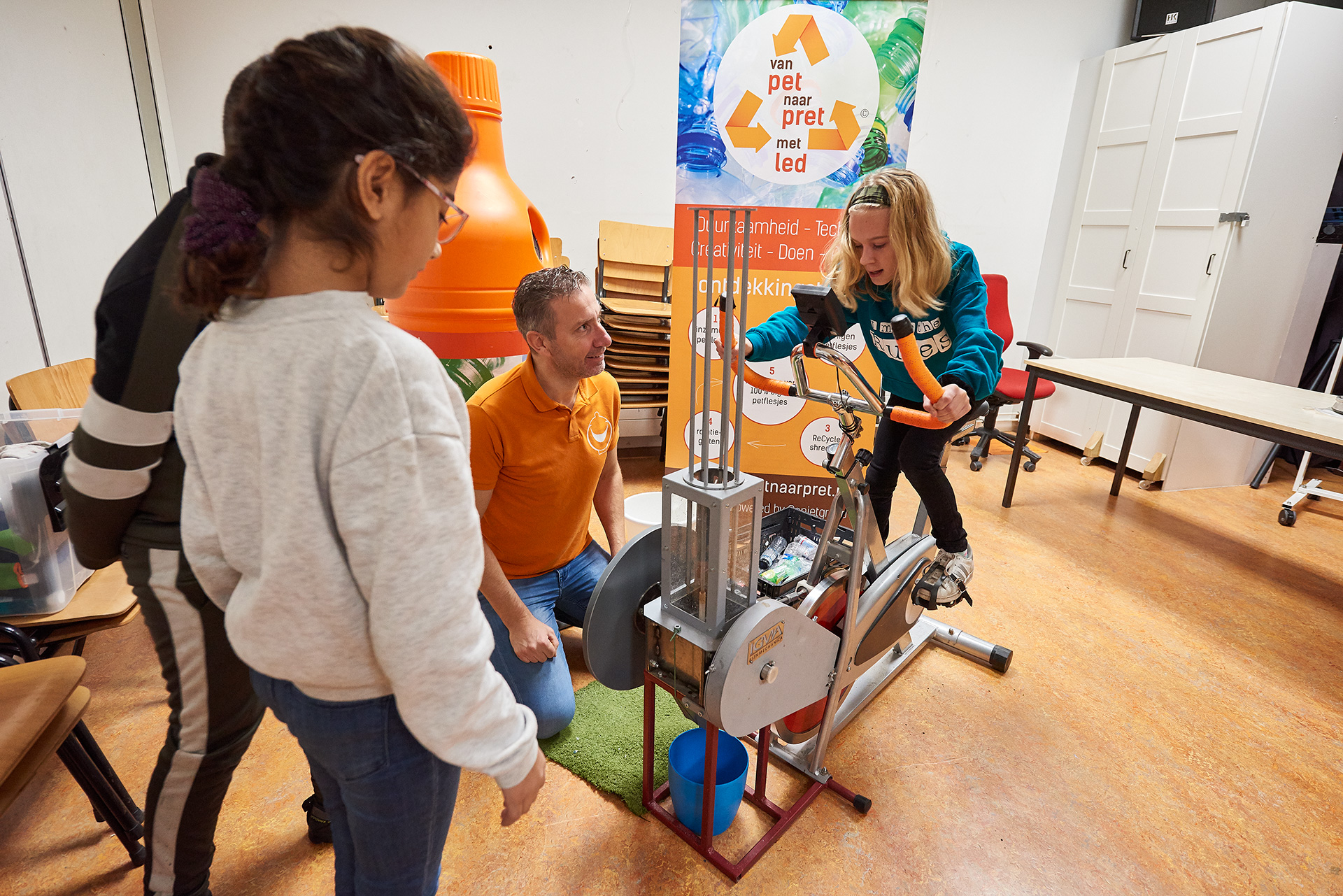 Leerling op de hometrainer met de leerkracht die erlangs zit