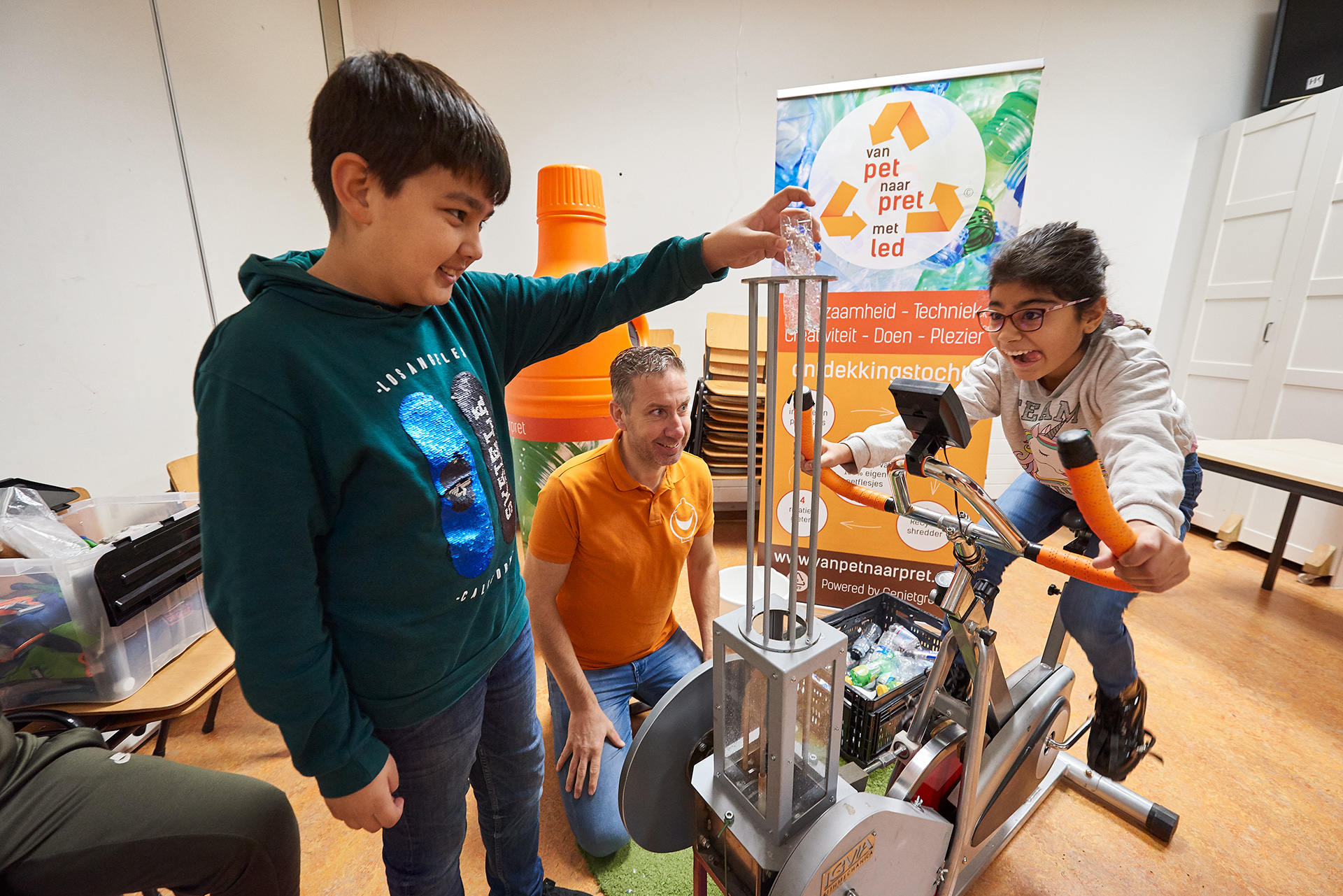 Leerling op de hometrainer met de leerkracht die erlangs zit