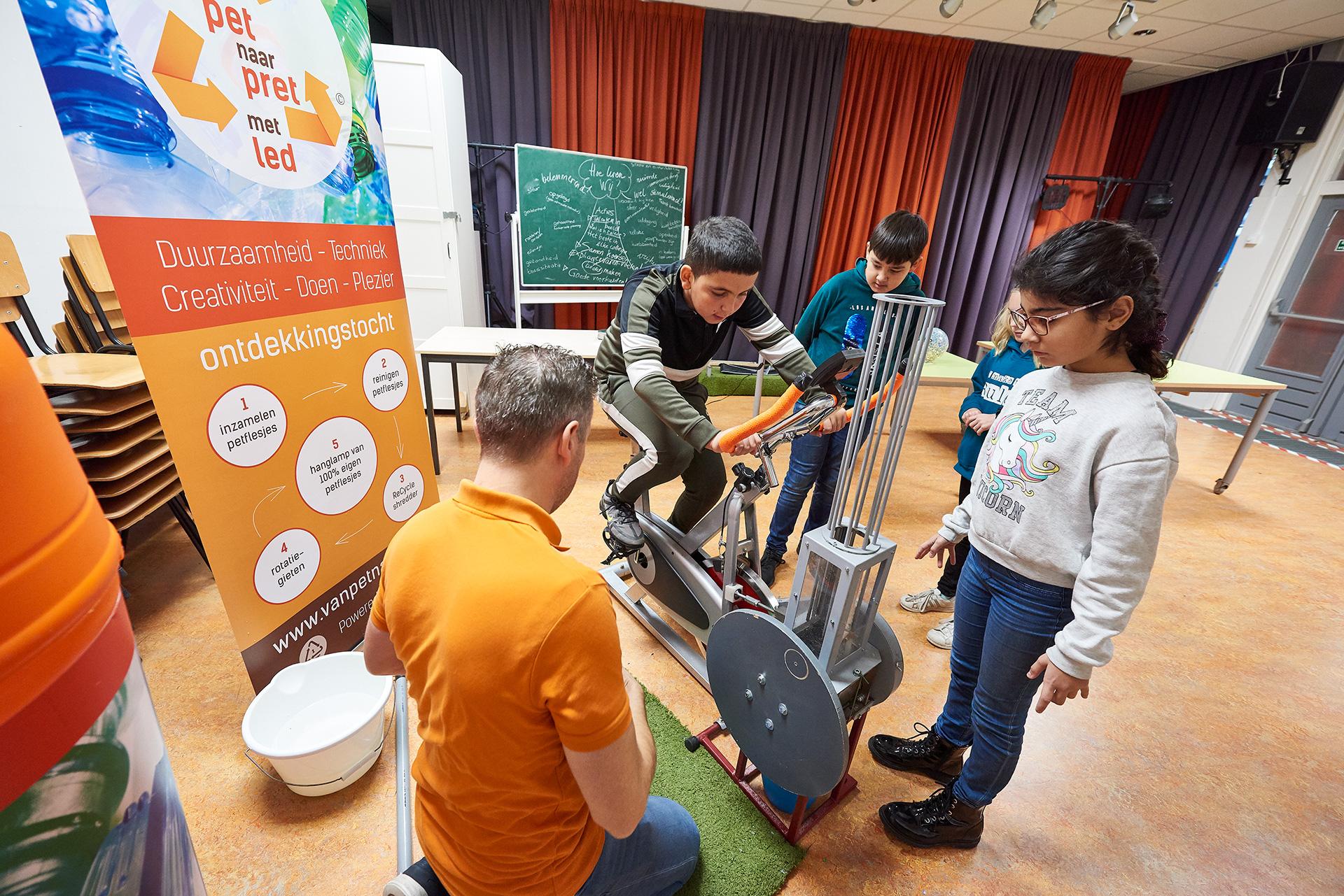 Leerling op de hometrainer met de leerkracht die erlangs zit