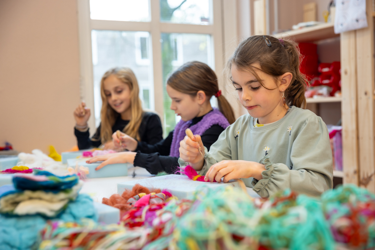 drie kinderen aan het vilten