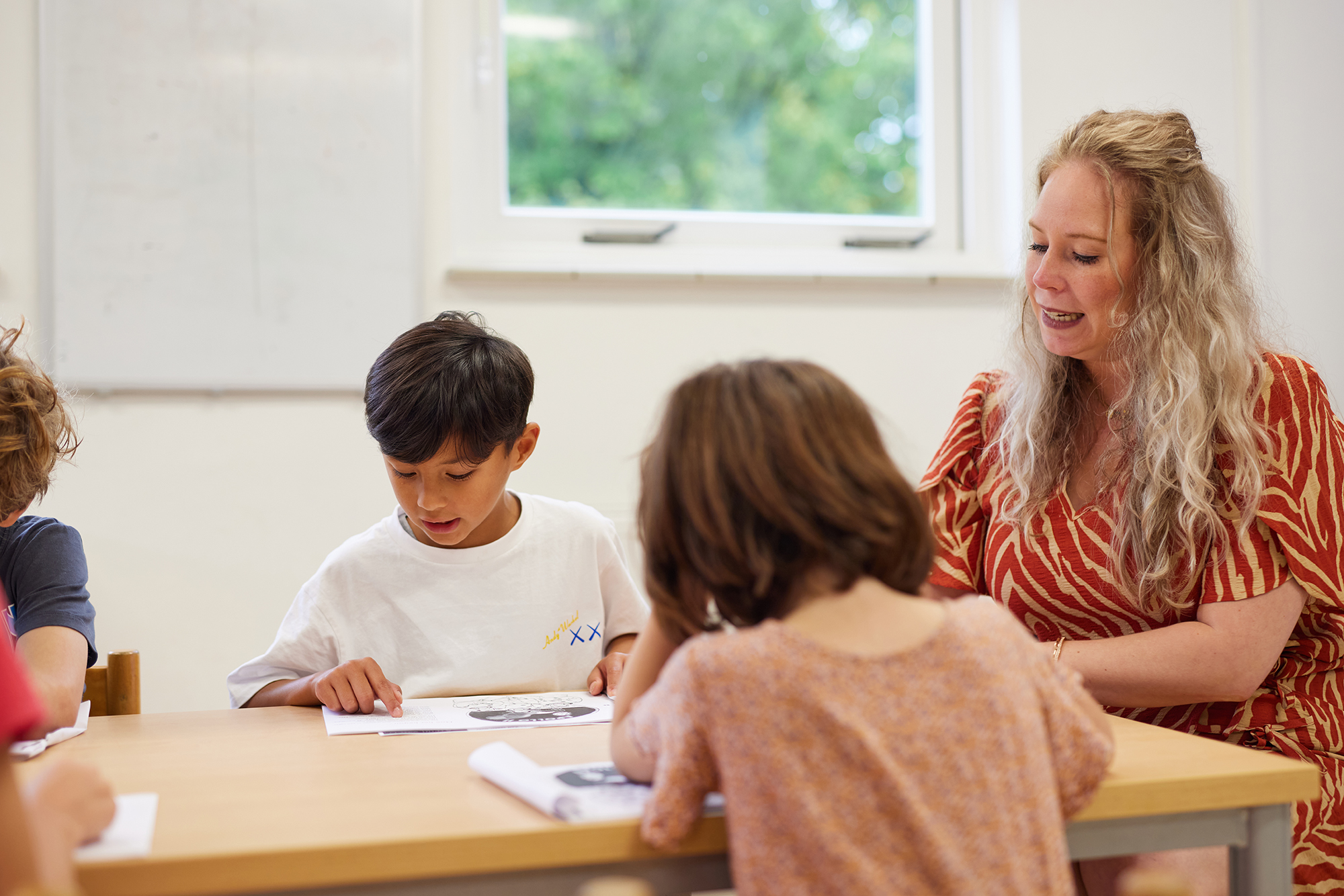 Docente aan tafel met leerlingen
