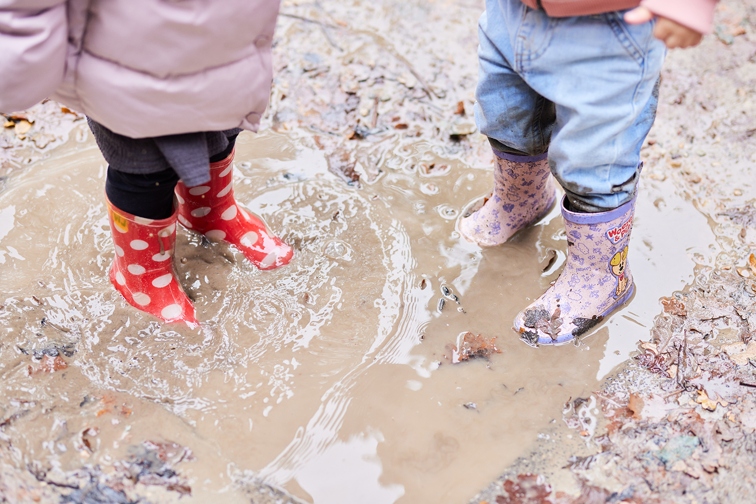 Kinderen stampen in regenplassen